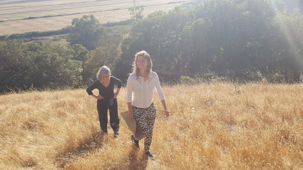 2 women hiking up a hill