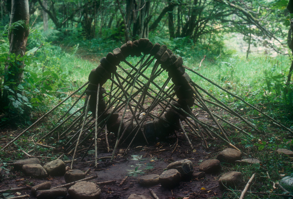 Sculpture in woods made of rocks and branches in circular shape