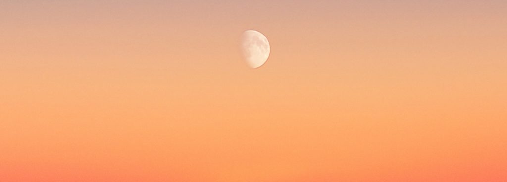 waxing gibbous moon in orange sky